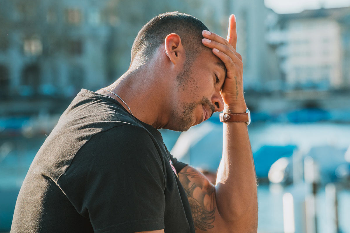 A man worried about debt with head in his hand